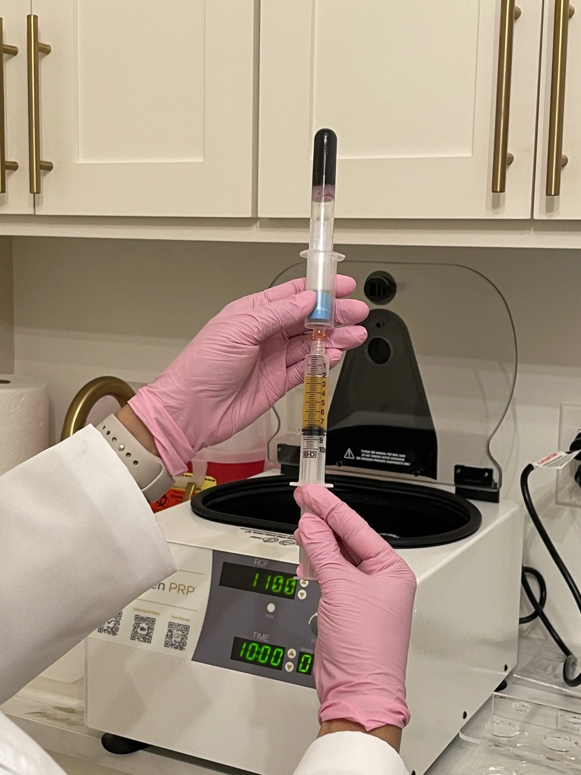 Plasma being drawn into a syringe from a processing tube above a centrifuge