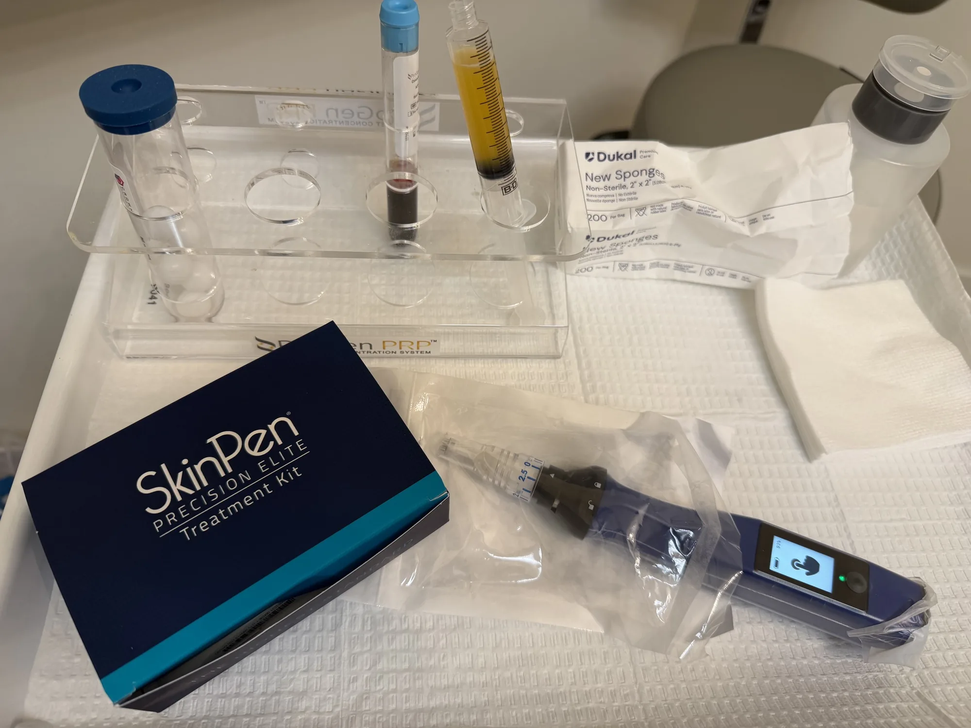 A SkinPen treatment kit beside a rack holding a blood tube and a syringe of plasma