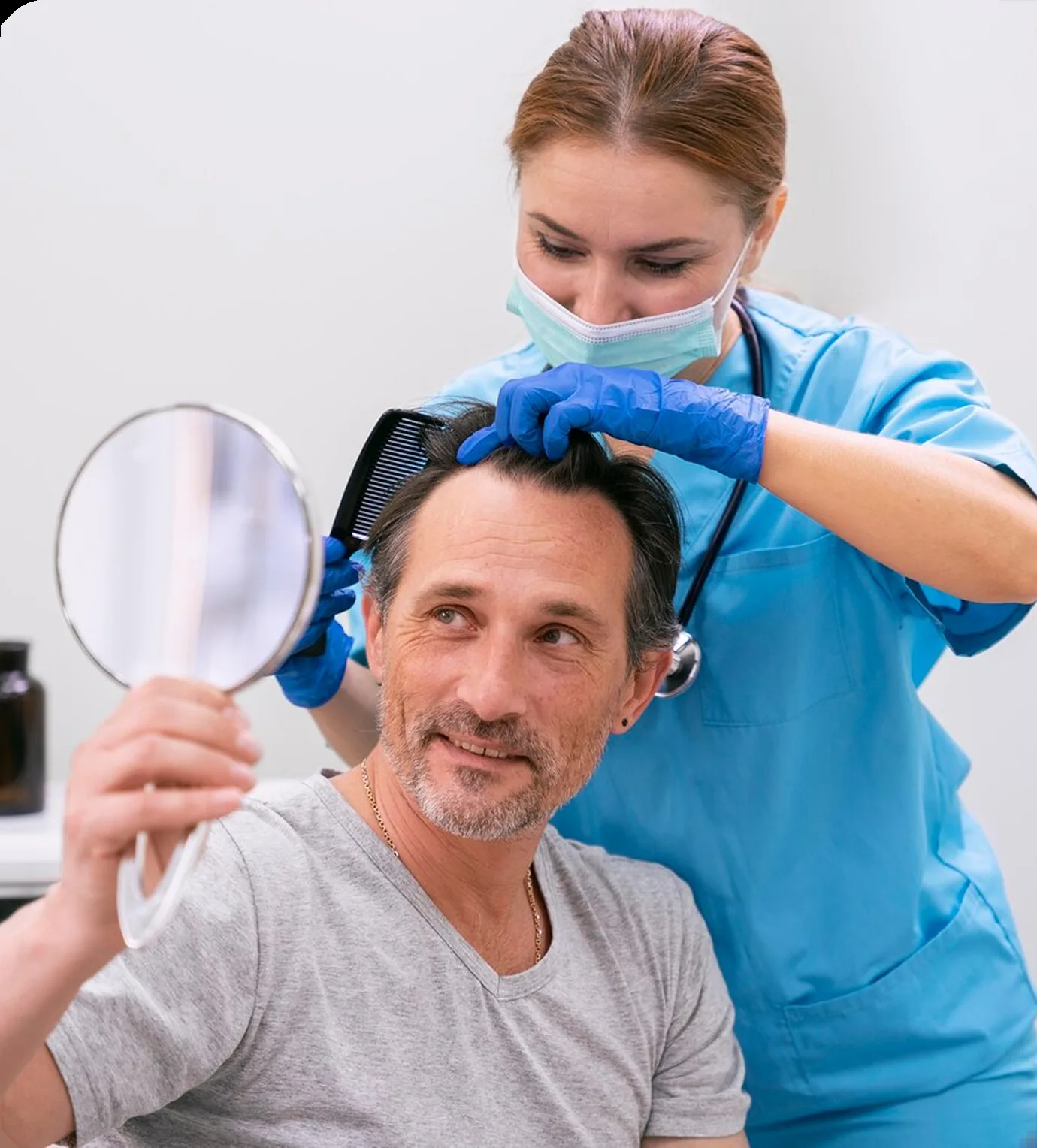 A clinician examining a man's scalp while he holds a mirror
