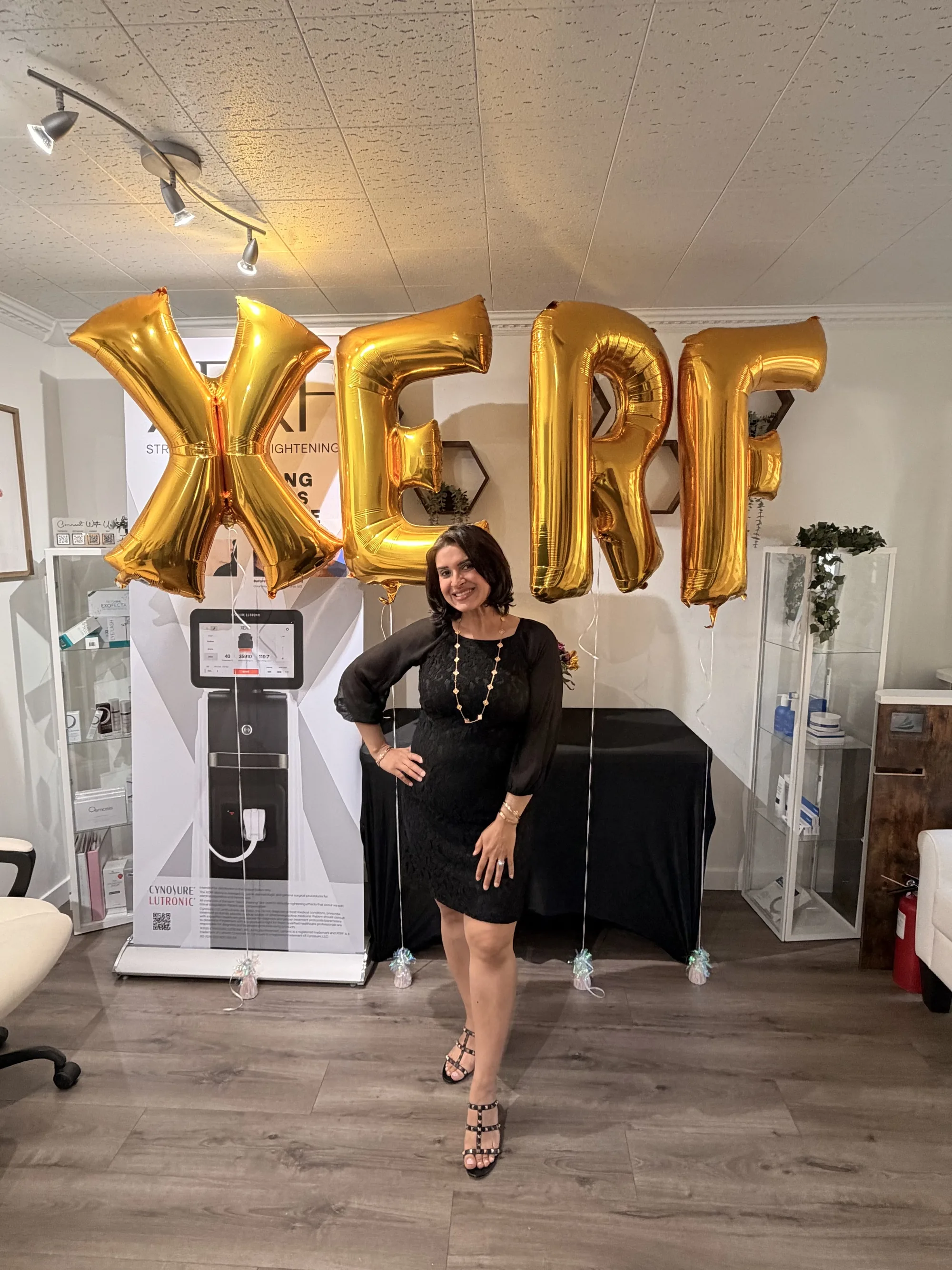 Dr. Inderpreet Sanghera standing under gold XERF balloons beside the XERF device and banner on launch day