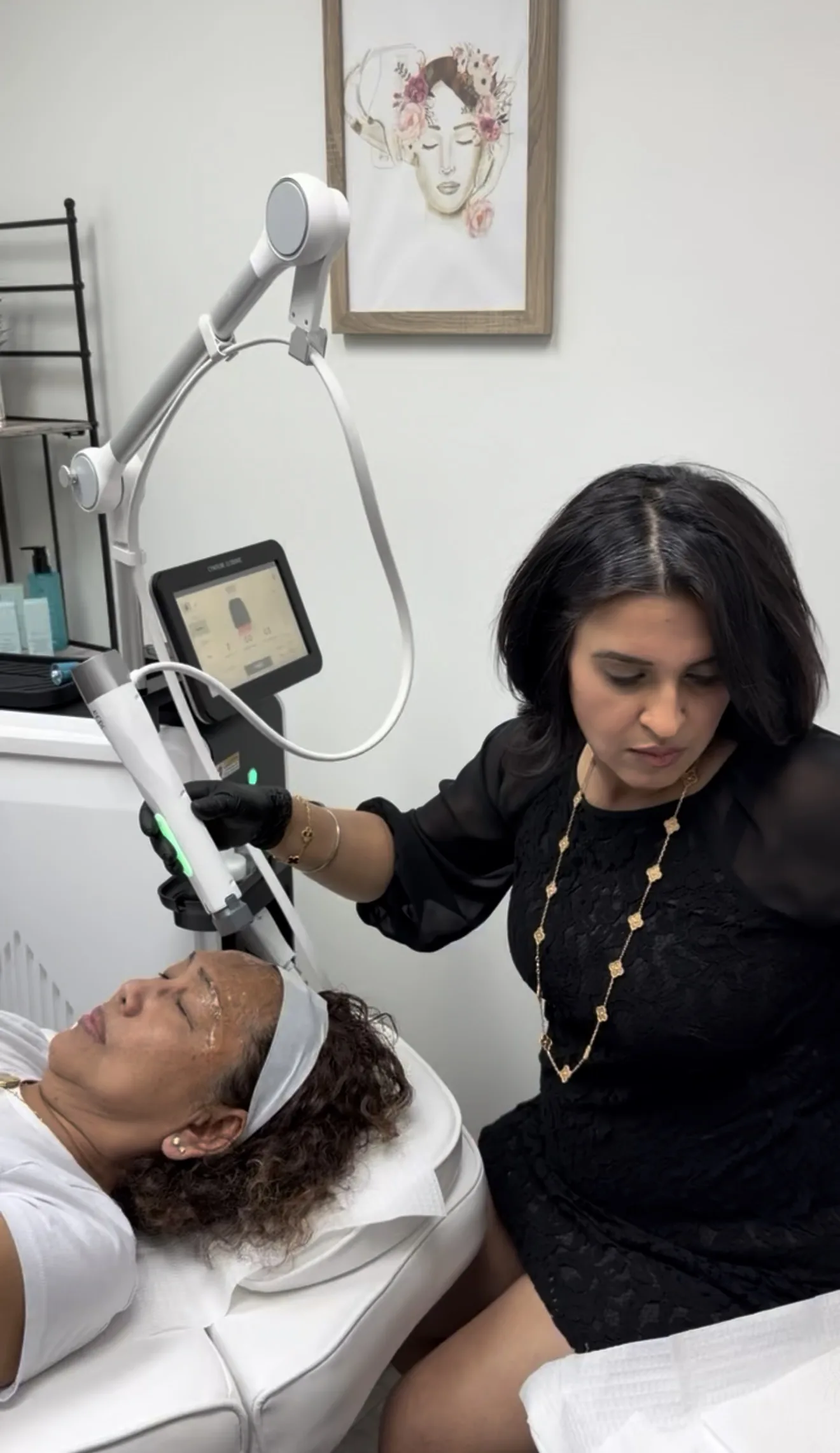 A provider in black gloves guiding the XERF handpiece across a patient's forehead, the device screen beside her